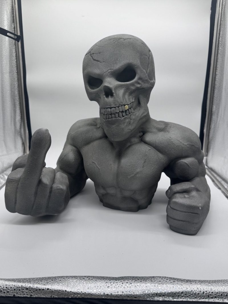 Statue tête de mort doigt d'honneur Skull Biker en peinture texturée gris effet métal – vue de face avec dent en or