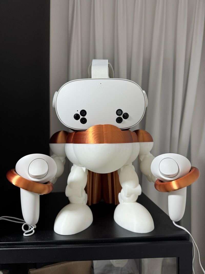 9b228940-f0a4-11f0-9a9a-e9ccad3b6a02.jpg Support casque VR Meta Quest « Robot » – station casque et manettes imprimée en 3D