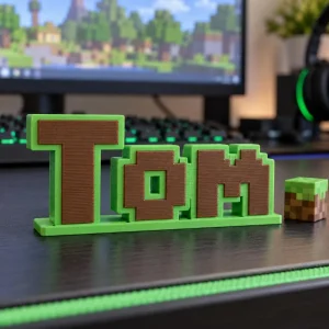 Prénom 3D Minecraft personnalisé à poser : lettres vertes et marron en pixels sur un bureau de joueur