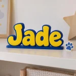 Prénom 3D Pat' Patrouille personnalisé à poser : lettres bleues et jaunes sur une étagère de petit enfant