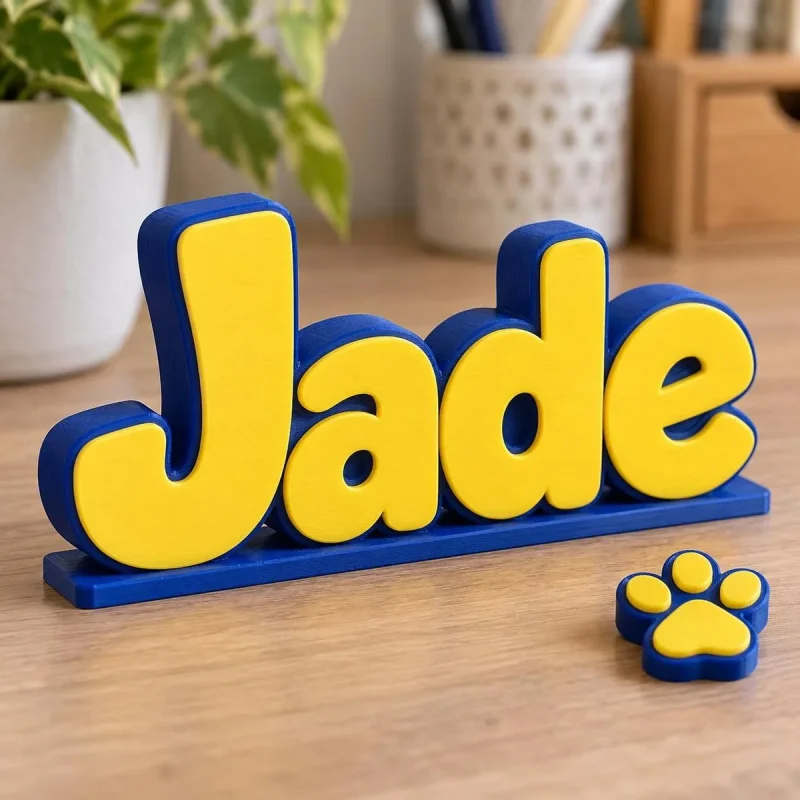 Prénom 3D Pat' Patrouille vu de près, lettres bicolores imprimées en 3D, avec un accessoire (empreinte de patte) en option
